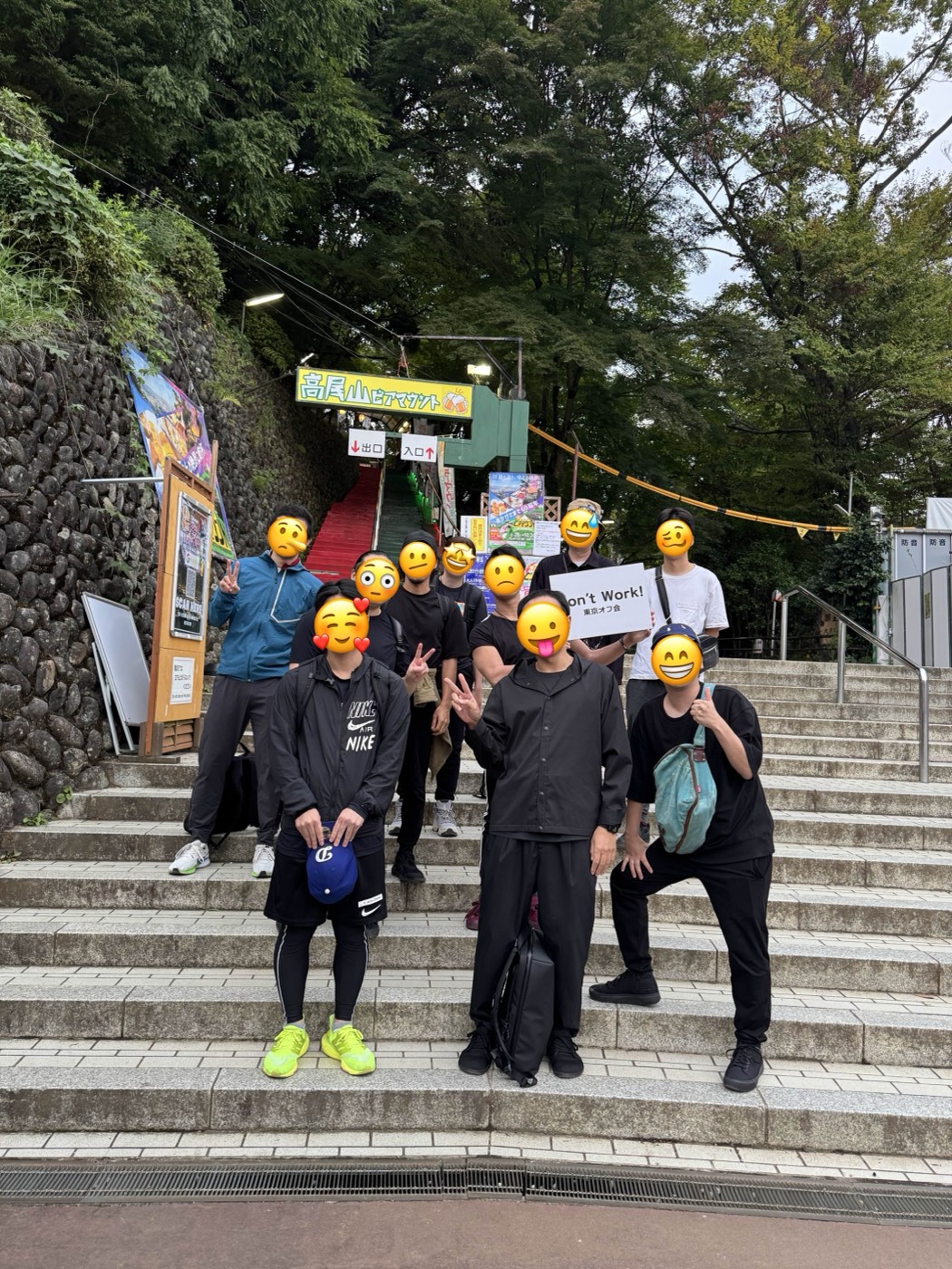 高尾山の登山口の階段で、Don’t Work!のボードを掲げて集合したメンバー